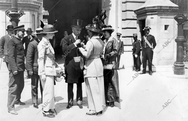 Damas aristocráticas colocando flores al Presidente del Consejo de Ministros al salir del Palacio Real. Fuente: Hemeroteca ABC 2-VI-1914.